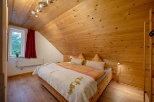 ein Schlafzimmer mit einem Bett in einem Holzzimmer in der Unterkunft Ferienhaus Störzel - Wohnung B in Hundheim