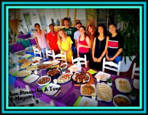 a group of people standing around a table with food at hôtel Oasis in Mamoudzou