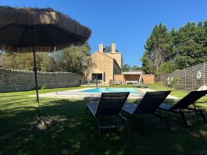 a table and chairs under an umbrella next to a swimming pool at Domaine la Boulinière - Le Sanglier in Journet
