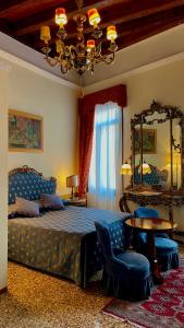 a bedroom with a bed and a table and a chandelier at Console Palais in Venice