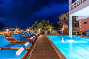 ヒマラにあるApart 5 Pool, Views, Kitchen, Parking and more - Goroの夜間のスイミングプールの横のラウンジチェアの列