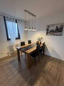 een eetkamer met een houten tafel en stoelen bij Bayreuth Apart No 7 in Bayreuth