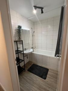 een badkamer met een wit bad en een wastafel bij Bayreuth Apart No 7 in Bayreuth