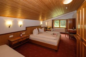 una camera con un grande letto e un soffitto in legno di Hotel Garni DIAS a Kappl