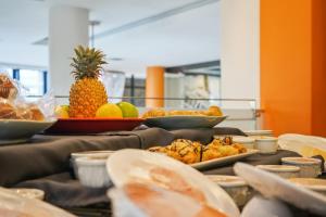 a table with plates of food and a pineapple on it at Colosseum Hotel in Cape Town +37 photos