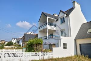 a white house with a white fence at LocaLise - A02 - Appartement de plain-pied - terrasse - Juste à côté de la plage - Centre et port à pied - Wifi inclus - Draps inclus - Animaux bienvenus in Tréffiagat