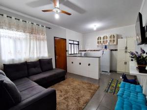 a living room with a couch and a kitchen at Casa mana in Olímpia
