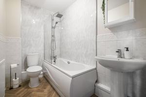 a white bathroom with a toilet and a sink at Modern & Comfortable with Free Parking in Bedford +40 photos