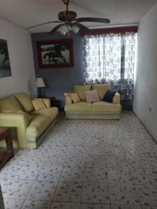 ein Wohnzimmer mit 2 Sofas und einem Deckenventilator in der Unterkunft Departamento in Villahermosa