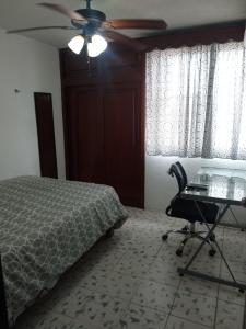 Schlafzimmer mit einem Bett, einem Schreibtisch und einem Deckenventilator in der Unterkunft Departamento in Villahermosa