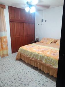 ein Schlafzimmer mit einem Bett und einem Holzschrank in der Unterkunft Departamento in Villahermosa