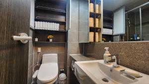 a bathroom with a white toilet and a sink at Haeundae Bada Stay in Busan +280 photos