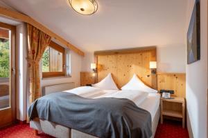 A bed or beds in a room at Hotel Alpenpanorama