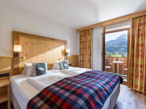 A bed or beds in a room at Hotel Alpenpanorama