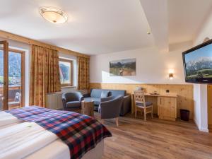 A bed or beds in a room at Hotel Alpenpanorama