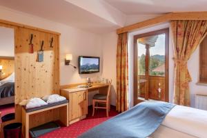 A bed or beds in a room at Hotel Alpenpanorama