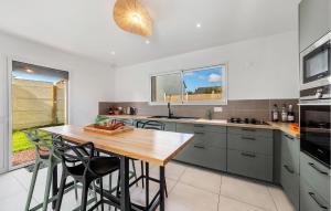 a kitchen with a wooden table and some chairs at Amazing Home In Saint-Méloir-Des-Ondes in Saint-Méloir-des-Ondes