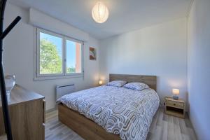 a bedroom with a bed and a window at Le Côtier - Appt à 200m de la plage in Courseulles-sur-Mer