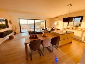 una cucina e un soggiorno con tavolo e sedie di Villa Casa Maredda bord de mer avec piscine a Palasca