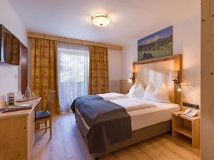 A bed or beds in a room at Hotel Alpenpanorama