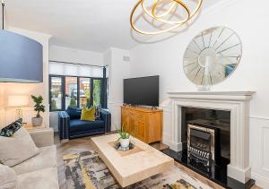 a living room with a fireplace and a tv at Malahide Castle Hideaway in Malahide