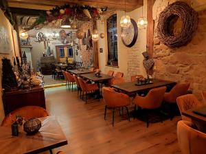 a restaurant with tables and chairs in a room at Hofgarten Rosa in Ilbesheim