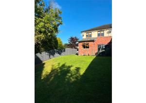 a house with a grassy yard next to a house at Malahide Castle Hideaway in Malahide
