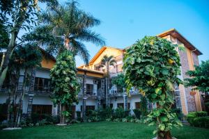 布琼布拉Pearl Residence Hotel的一座棕榈树建筑