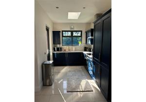 a kitchen with black cabinets and a window at Malahide Castle Hideaway in Malahide +58 photos