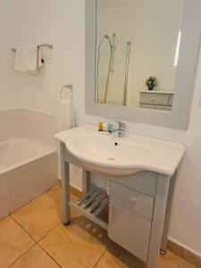 a bathroom with a sink and a mirror and a tub at The Dunes Studio 38 in Plettenberg Bay