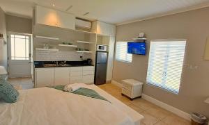 a bedroom with a large bed and a kitchen at The Dunes Studio 38 in Plettenberg Bay +3 photos