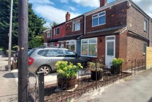 Un coche aparcado frente a una casa de ladrillo con plantas en macetas. en Hull 3Bed House-Driveway-Garden-FamilyFriendly, en Hull