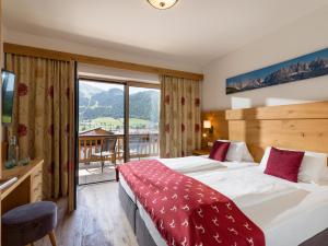 A bed or beds in a room at Hotel Alpenpanorama