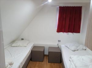 two beds in a room with a red window at Terrasses de Malmedy Chalet 141 in Malmedy