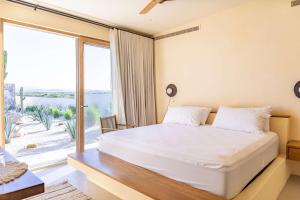 Secluded Luxury Beachfront Villa in La Ribera في La Laguna: غرفة نوم بسرير كبير ونافذة كبيرة