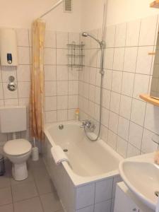 a bathroom with a tub and a toilet and a sink at Schwalbacher Residenz in Frankfurt/Main