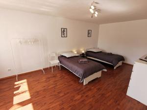 two beds in a room with wood floors at FR14 - Schöne 2-Zimmer-Wohnung mit Balkon in Heusenstamm in Heusenstamm