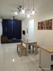 a living room with a table and a couch at Alam Indah Homestay in Bandar Puncak Alam