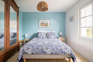 a bedroom with a bed with blue walls and windows at La Villa Moursoise 4 Etoiles in Mours-Saint-EusÃ¨be