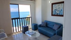 a living room with a blue couch and a large window at apartamento-rodadero-laureles-1601 by reservastodo in Santa Marta +4 photos