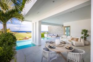 a living room with a table and chairs and a pool at The Cape at Blue Bay Golf & Beach Resort in Sint Michiel