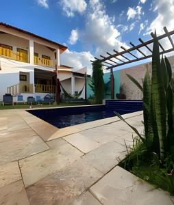 a villa with a swimming pool and a house at Cerrado 07 - Suítes individuais em pousada in Pirenópolis