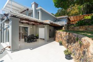 een huis met een stenen muur en een patio bij Coney Glen Views in Knysna