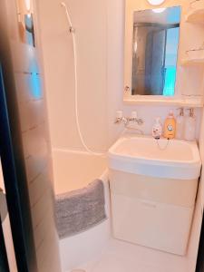 un bagno con lavandino, specchio e doccia di アパートホテルMk札幌駅前 a Kita-rokujō Altre 19 foto