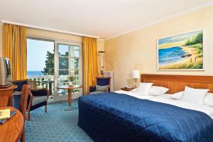 Cette chambre comprend un lit et une grande fenêtre. dans l'établissement Hotel Kleine Strandburg - Adults Only, à Zinnowitz