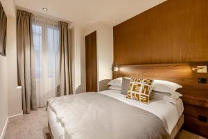a bedroom with a large bed with a wooden headboard at Le Madame By Sweett in Paris