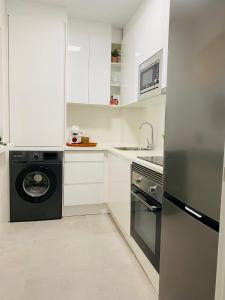 a white kitchen with a washer and dryer in it at Aire del mediterráneo- Garrucha in Garrucha