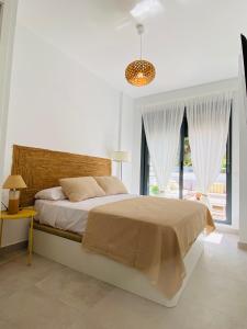 a white bedroom with a large bed and a window at Aire del mediterráneo- Garrucha in Garrucha