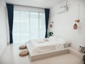 a white bedroom with a bed with a window at Fivehouse Silom1 - City heart - Silom -BTS MRT 2min - lumpini park - bnh in Bangkok