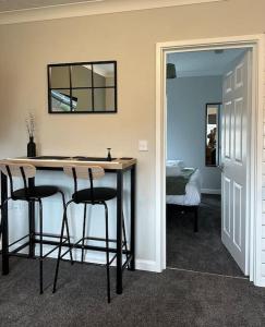 a room with a table with two chairs and a mirror at Walnut House - Modern 1 Bedroom Apartment very close to town by Shortstays4u in Kings Lynn